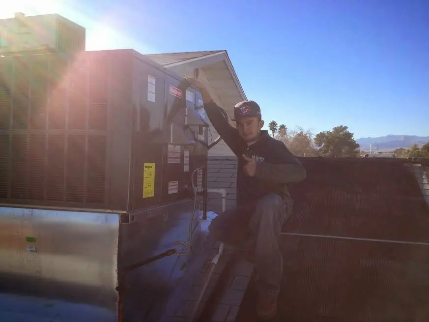 HVAC technician performing AC Tune-Up on a rooftop unit in Waikele